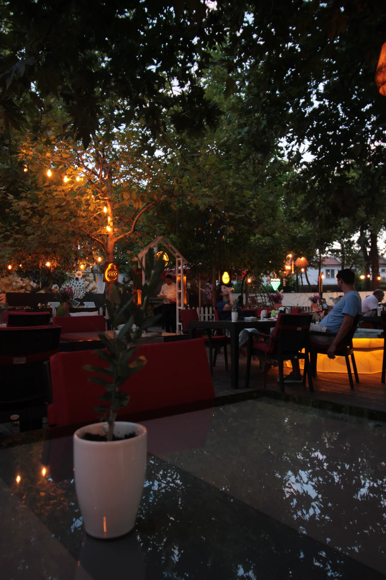 Sarı ışıklarla aydınlanan Ege Restaurant akşam bahçesi
